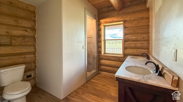 5236 North Holly Way Helper, UT 84526 - Photo 10 of 34 Full bathroom with rustic walls, wood finished floors, double vanity, toilet, and wood ceiling with exposed beams