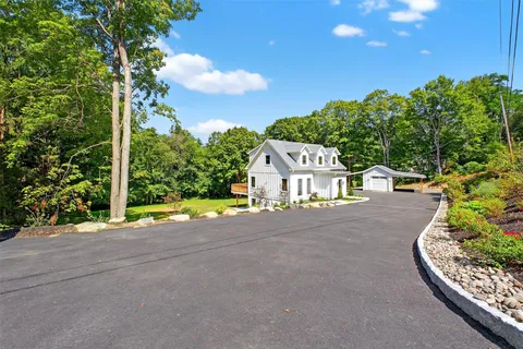 a view of road with house and trees in the background
