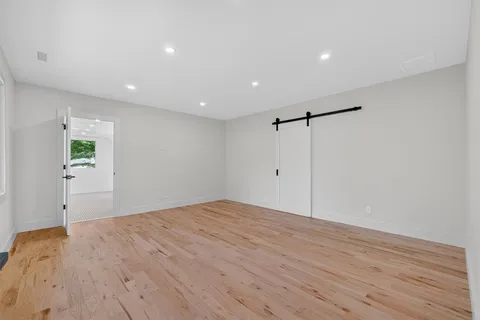 a view of empty room with wooden floor