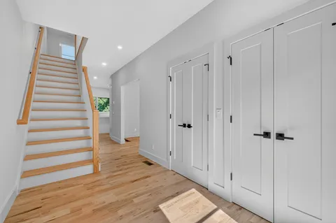 a view of a hallway with wooden floor and entryway