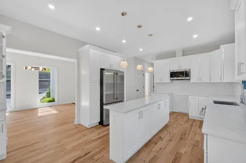 a large kitchen with stainless steel appliances a refrigerator and a stove top oven