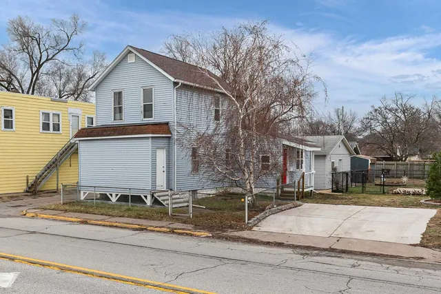 a view of a house with a yard and large tree