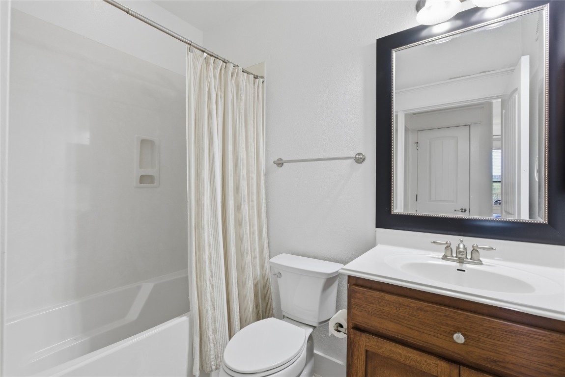 17700 Edgewood Way, Unit 101 Jonestown, TX 78645 - Photo 18 of 40 a bathroom with a granite countertop sink toilet a mirror and shower