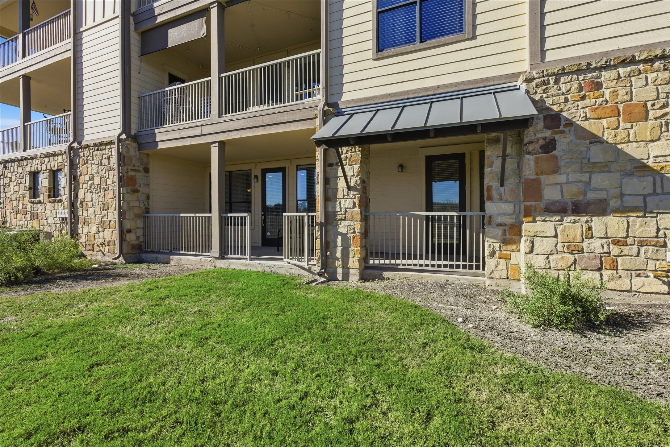 17700 Edgewood Way, Unit 101 Jonestown, TX 78645 - Photo 25 of 40 a view of a house with a small yard and wooden fence and floor to ceiling window