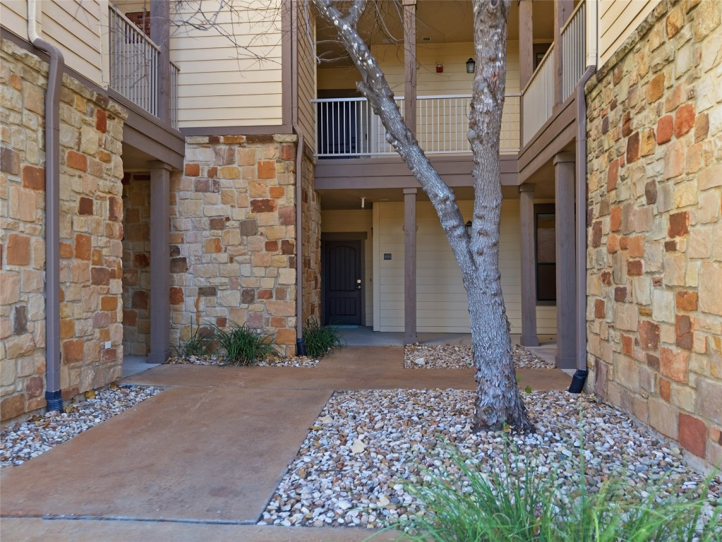 17700 Edgewood Way, Unit 101 Jonestown, TX 78645 - Photo 3 of 40 a front view of a building with a garden