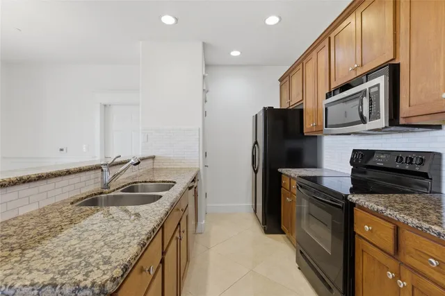 a kitchen with stainless steel appliances granite countertop a sink stove and refrigerator