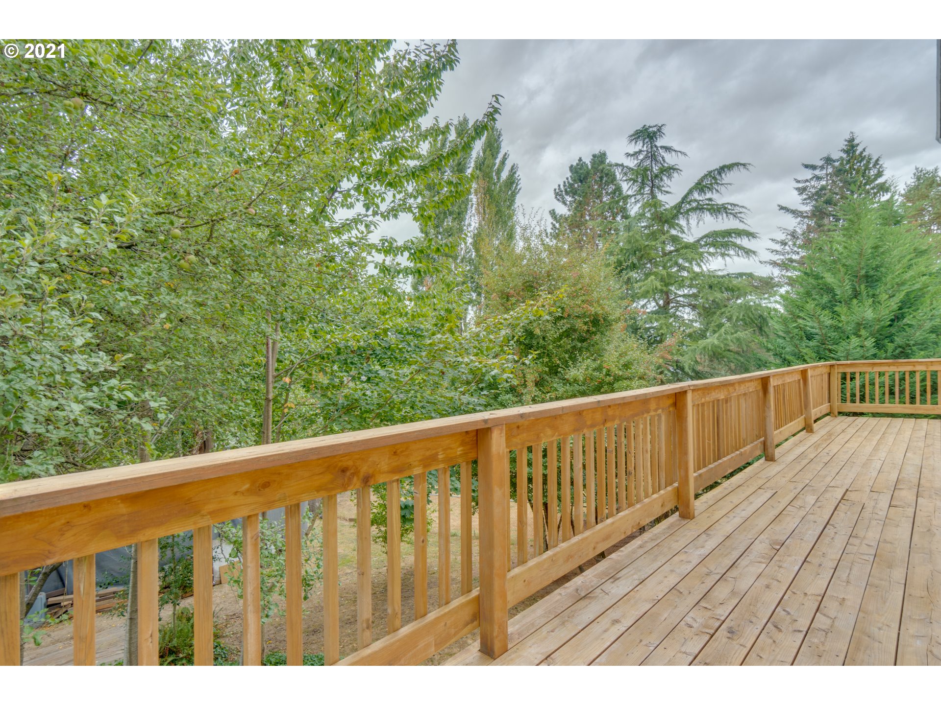 295 South Hillhurst Road Ridgefield, WA 98642 - Photo 20 of 32 a balcony with wooden floor and fence