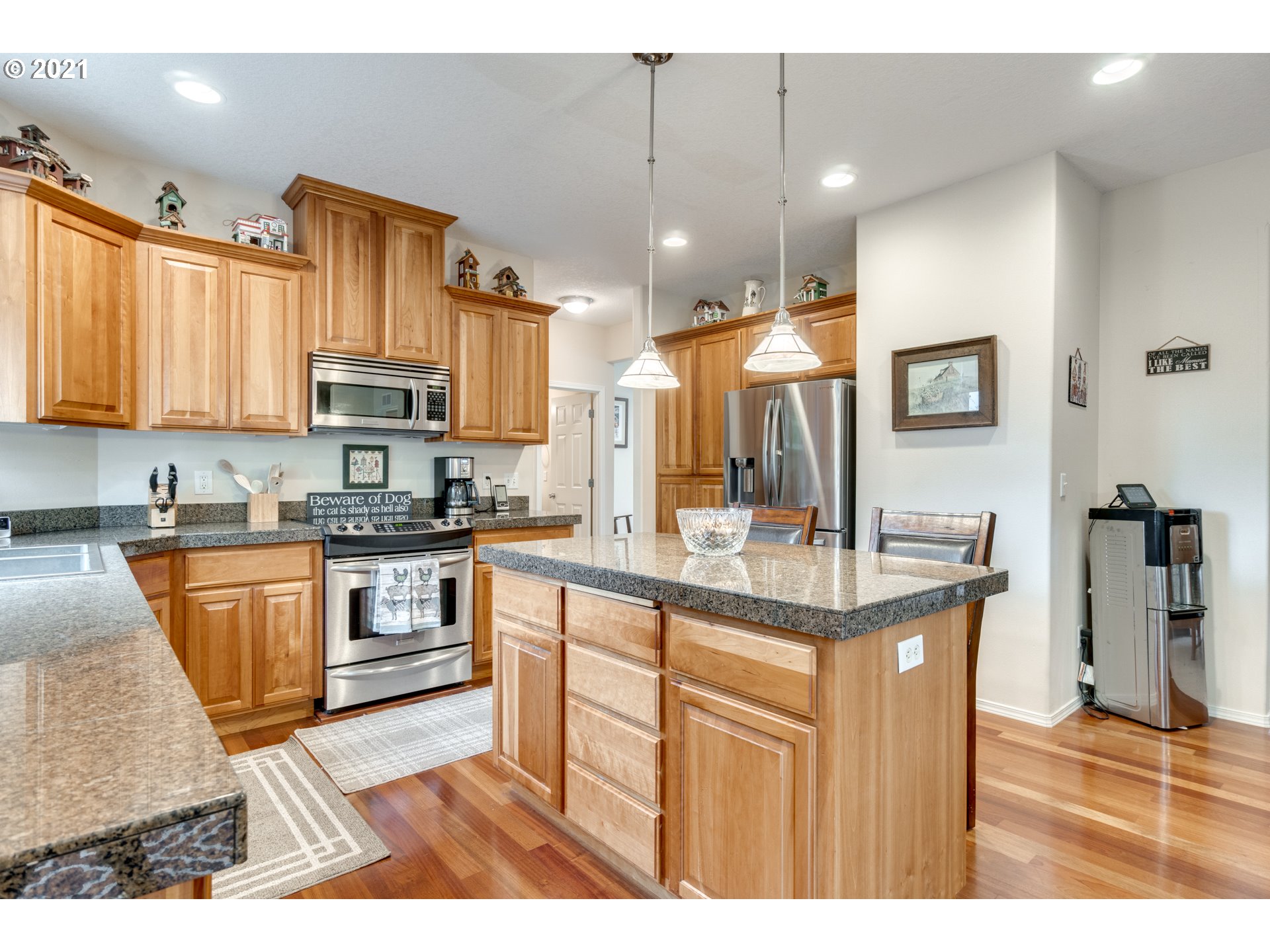 295 South Hillhurst Road Ridgefield, WA 98642 - Photo 7 of 32 a kitchen with stainless steel appliances kitchen island granite countertop a sink refrigerator and cabinets