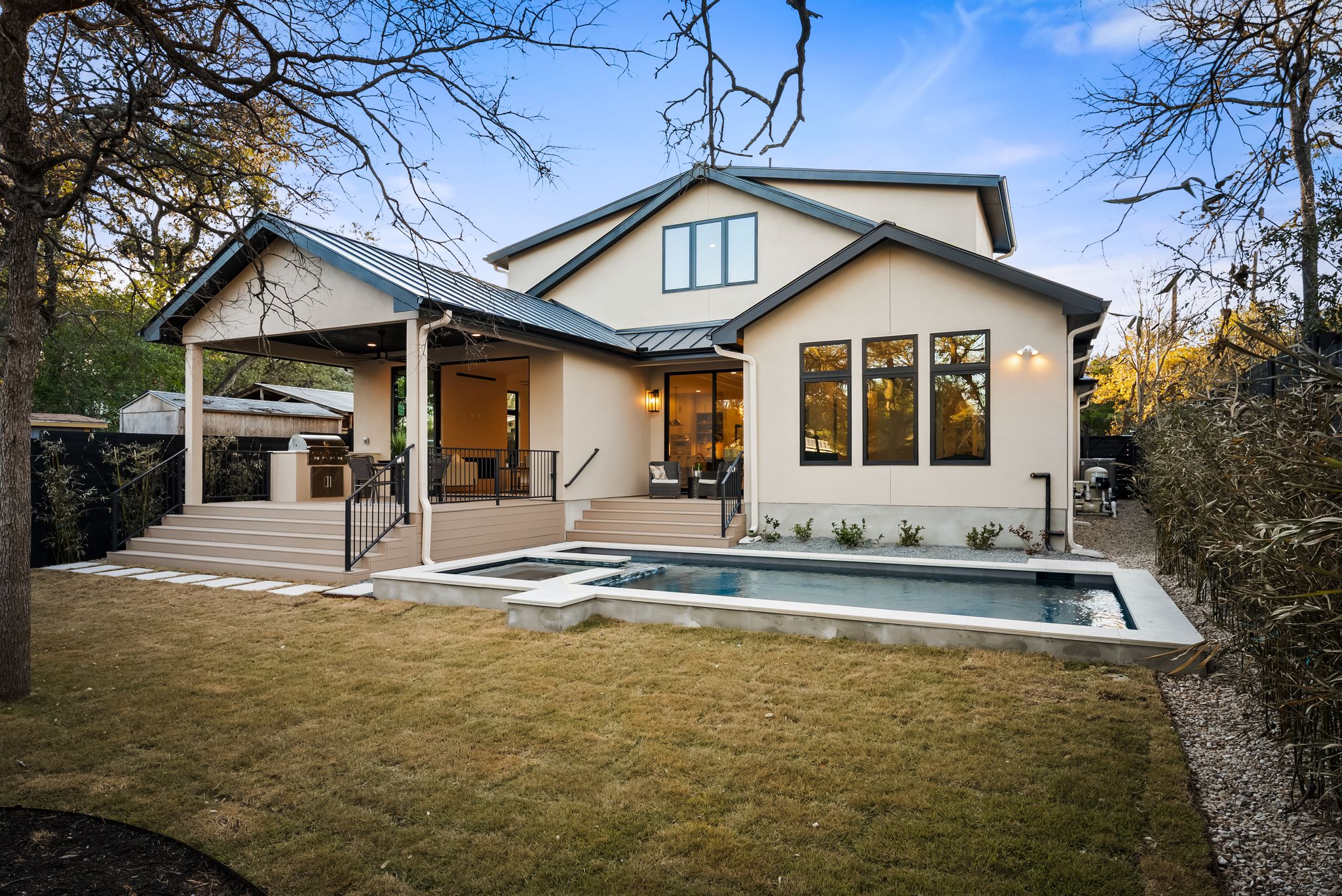 1607 Rabb Road Austin, TX 78704 - Photo 33 of 40 Back of house featuring area for grilling, a patio area, a standing seam roof, stucco siding, and a pool with connected hot tub