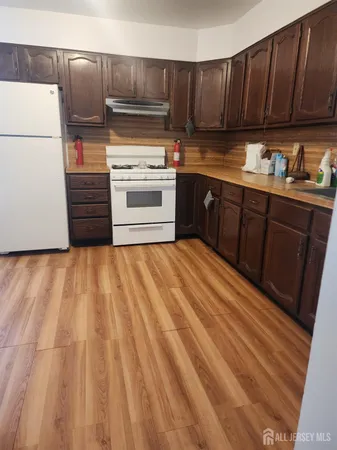 a kitchen with wooden cabinets and white appliances