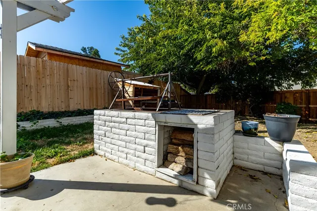 a view of a patio with table and chairs potted plants and a barbeque