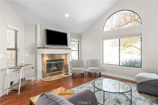 a living room with furniture a flat screen tv and a fireplace
