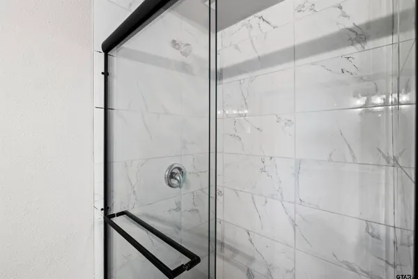 a bathroom with a glass shower door