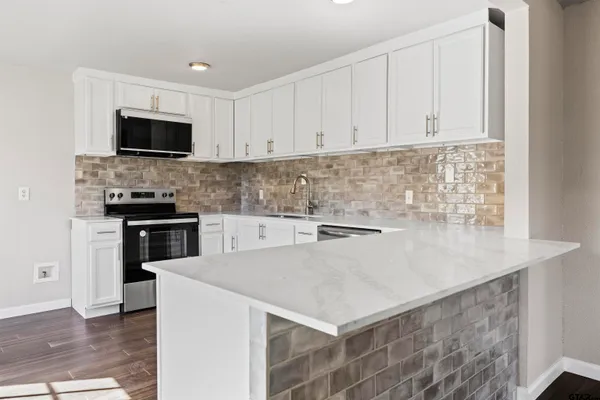 a kitchen with stainless steel appliances a stove microwave and sink