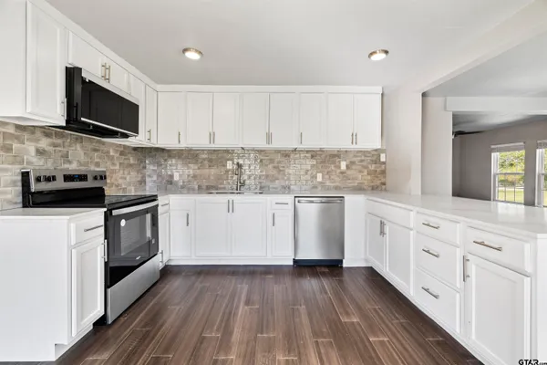 a kitchen with granite countertop white cabinets and white appliances