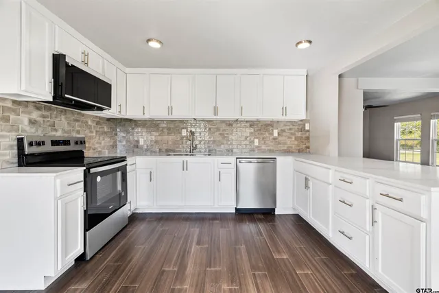 a kitchen with granite countertop white cabinets and white appliances