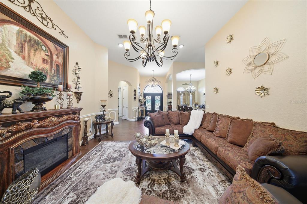 13429 Montevista Road Clermont, FL 34711 - Photo 13 of 89 a living room with furniture a chandelier and a fireplace