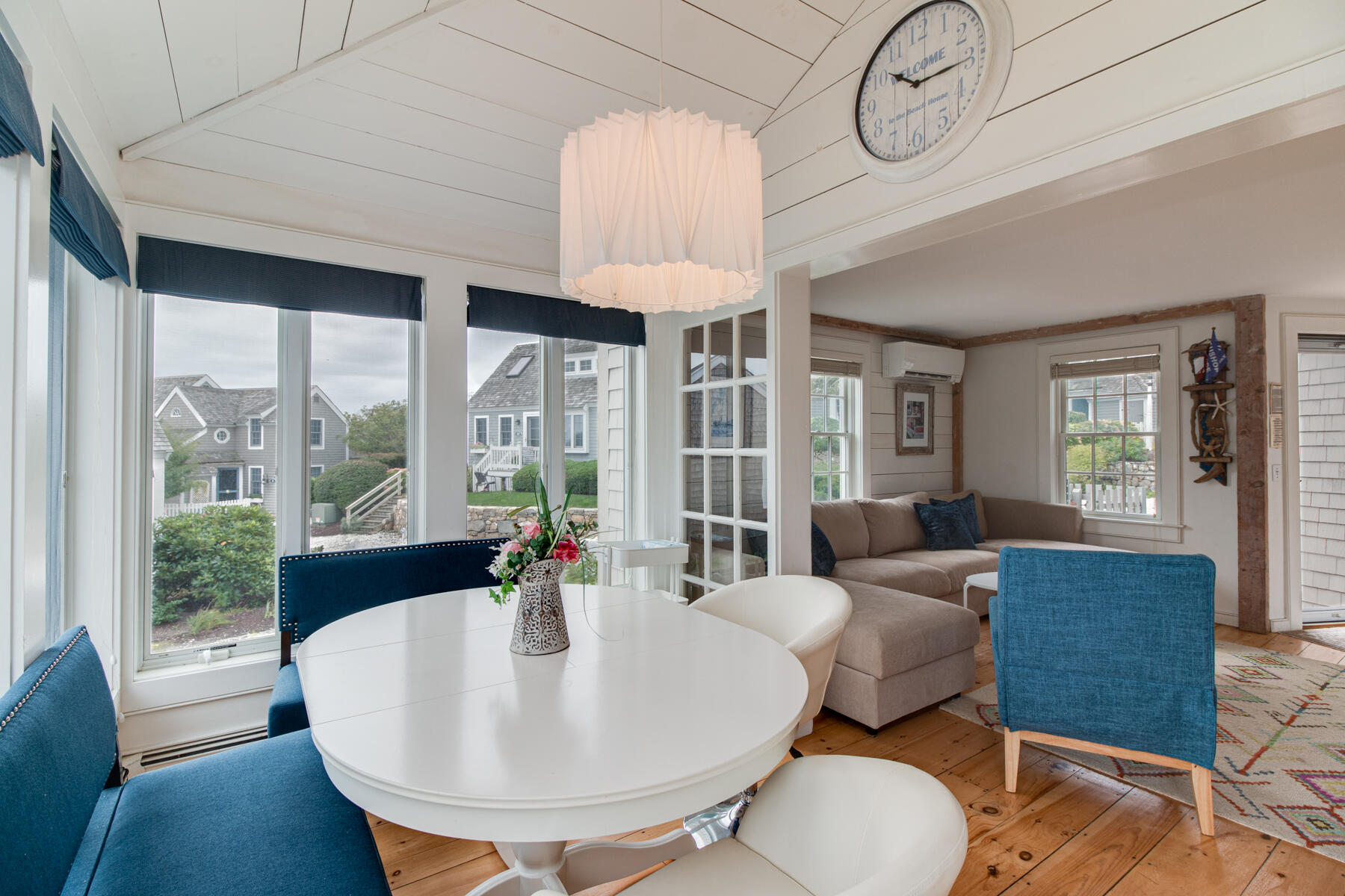 15 Brant Rock Road, Unit 765 Mashpee, MA 02649 - Photo 5 of 17 a living room with large couches chandelier and a dining table with wooden floor