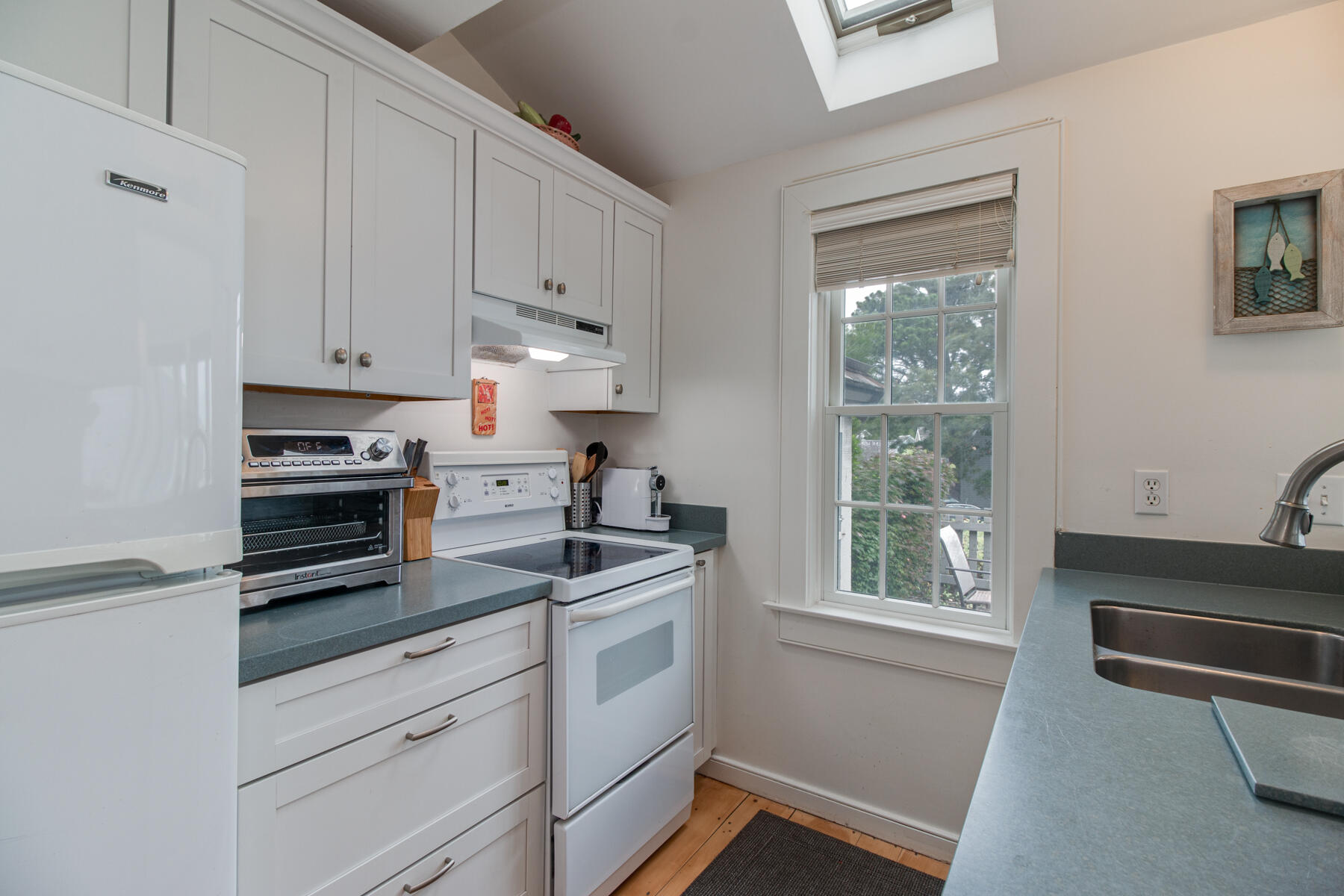 15 Brant Rock Road, Unit 765 Mashpee, MA 02649 - Photo 6 of 17 a kitchen with granite countertop white cabinets appliances and a window