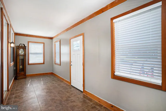 a view of empty room with window and refrigerator