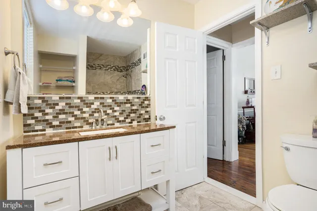a bathroom with a sink and a mirror with toilet