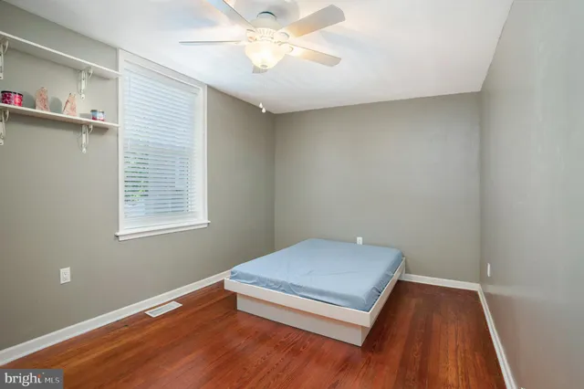 a view of a room with wooden floor and fan