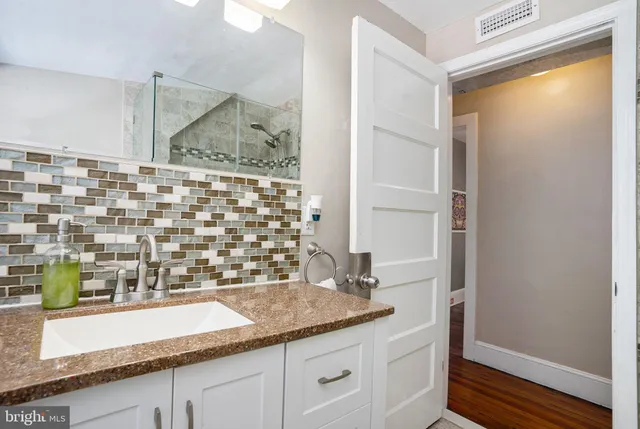 a bathroom with a granite countertop sink and a mirror