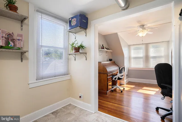 a view of a workspace with furniture and a window