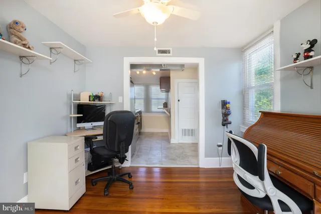 a view of a workspace with furniture and a window