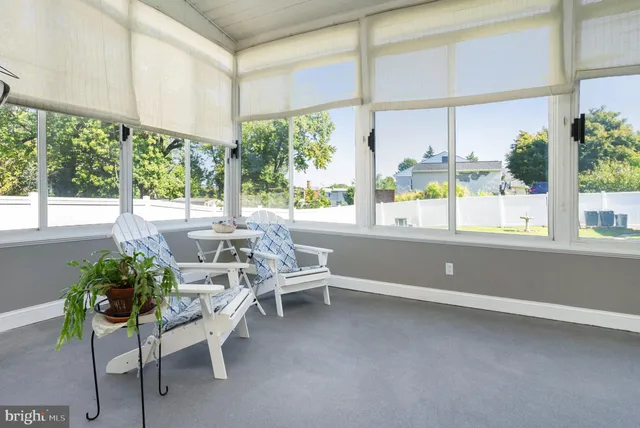 a living room with a large window a table and chairs