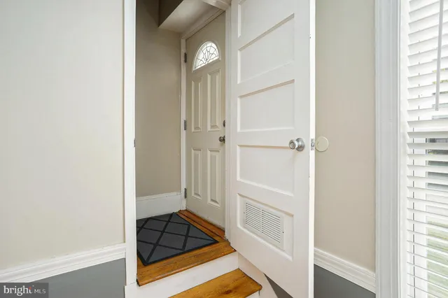 a view of a hallway with wooden floor and a door