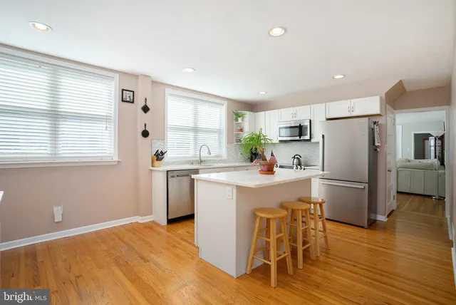 a kitchen with a refrigerator a sink dishwasher with a dining table and chairs