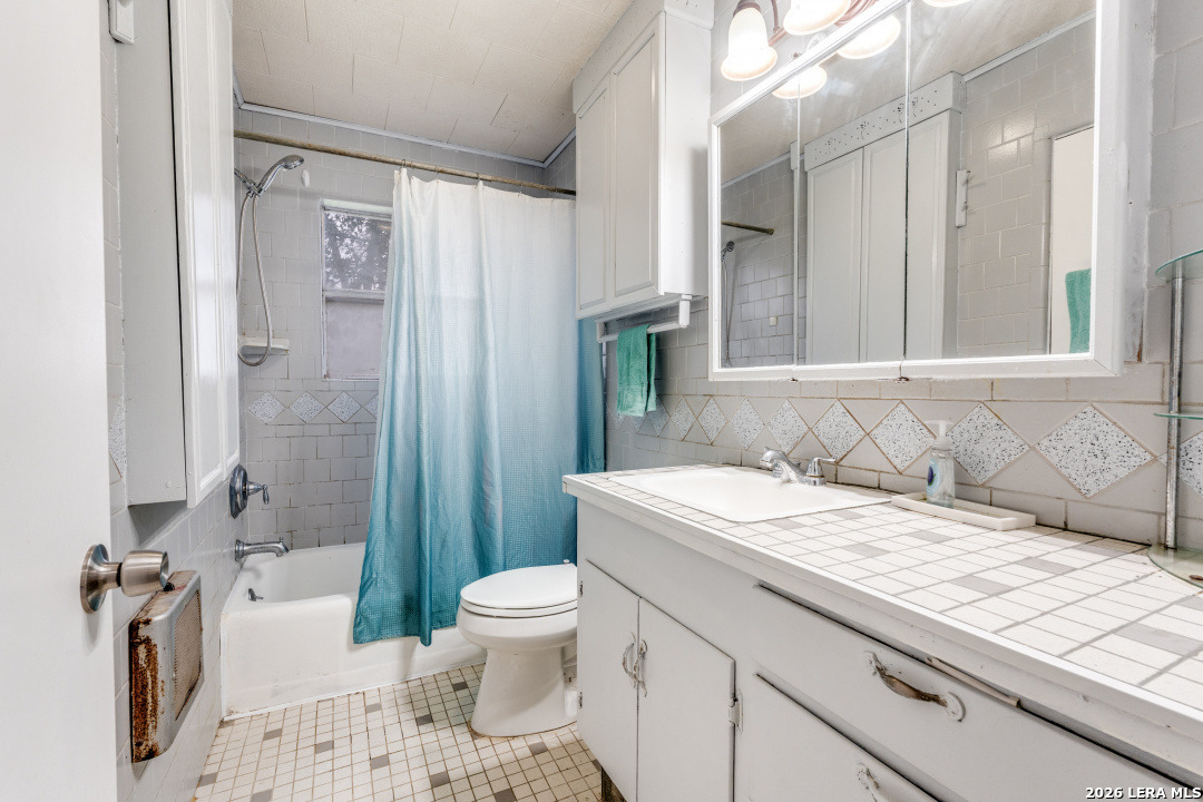 914 6th Street Blanco, TX 78606 - Photo 15 of 26 a bathroom with a granite countertop sink toilet and shower