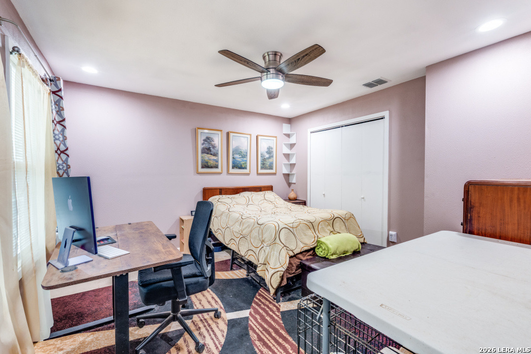 914 6th Street Blanco, TX 78606 - Photo 18 of 26 a bedroom with a bed and a chandelier