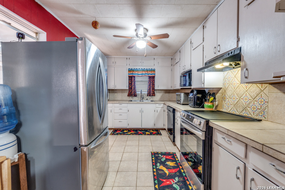 914 6th Street Blanco, TX 78606 - Photo 8 of 26 a kitchen with stainless steel appliances granite countertop a sink refrigerator and cabinets