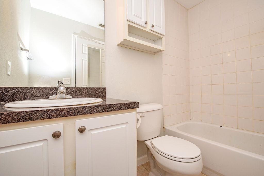 4420 Carter Road, Unit 44 St. Augustine, FL 32086 - Photo 9 of 18 a bathroom with a granite countertop sink a toilet a mirror and bathtub