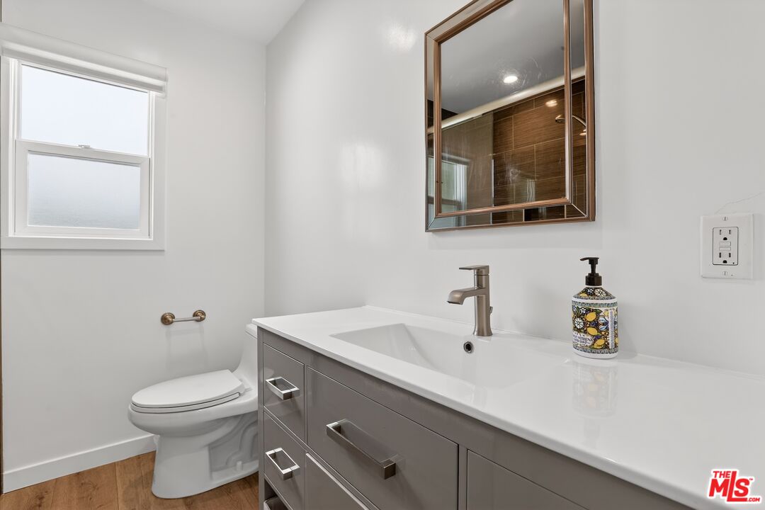 6565 Randi Avenue Woodland Hills, CA 91303 - Photo 12 of 25 a bathroom with a toilet a sink a vanity and mirror