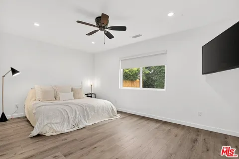 a bedroom with a bed and a flat screen tv