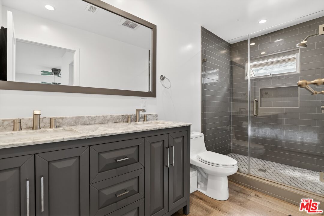 6565 Randi Avenue Woodland Hills, CA 91303 - Photo 15 of 25 a bathroom with a granite countertop sink toilet and shower