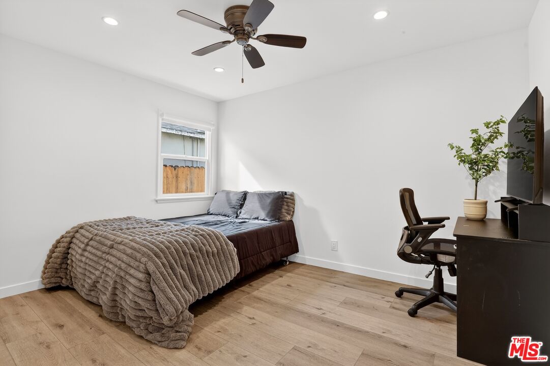 6565 Randi Avenue Woodland Hills, CA 91303 - Photo 19 of 25 a bedroom with a bed a desk and chair