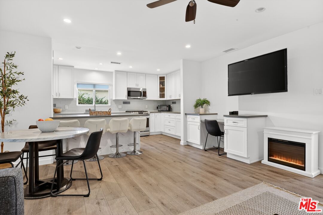 6565 Randi Avenue Woodland Hills, CA 91303 - Photo 5 of 25 a kitchen with a sink a microwave a stove and cabinets