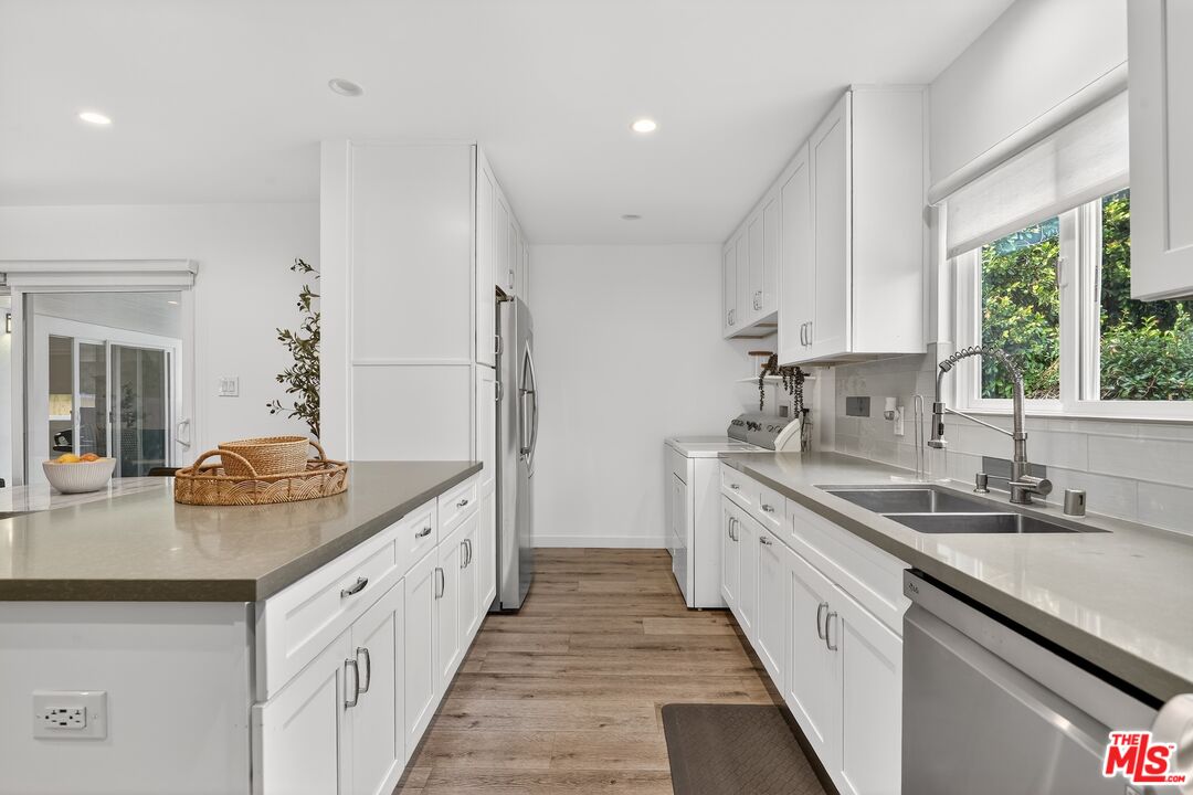 6565 Randi Avenue Woodland Hills, CA 91303 - Photo 9 of 25 a kitchen with granite countertop a sink and cabinets