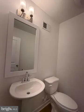 a bathroom with a sink a toilet and mirror