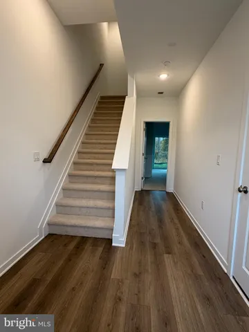 a view of entryway and hall with wooden floor