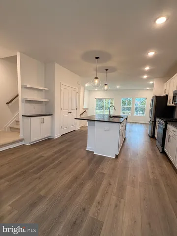 a view of a kitchen with wooden floor and electronic appliances