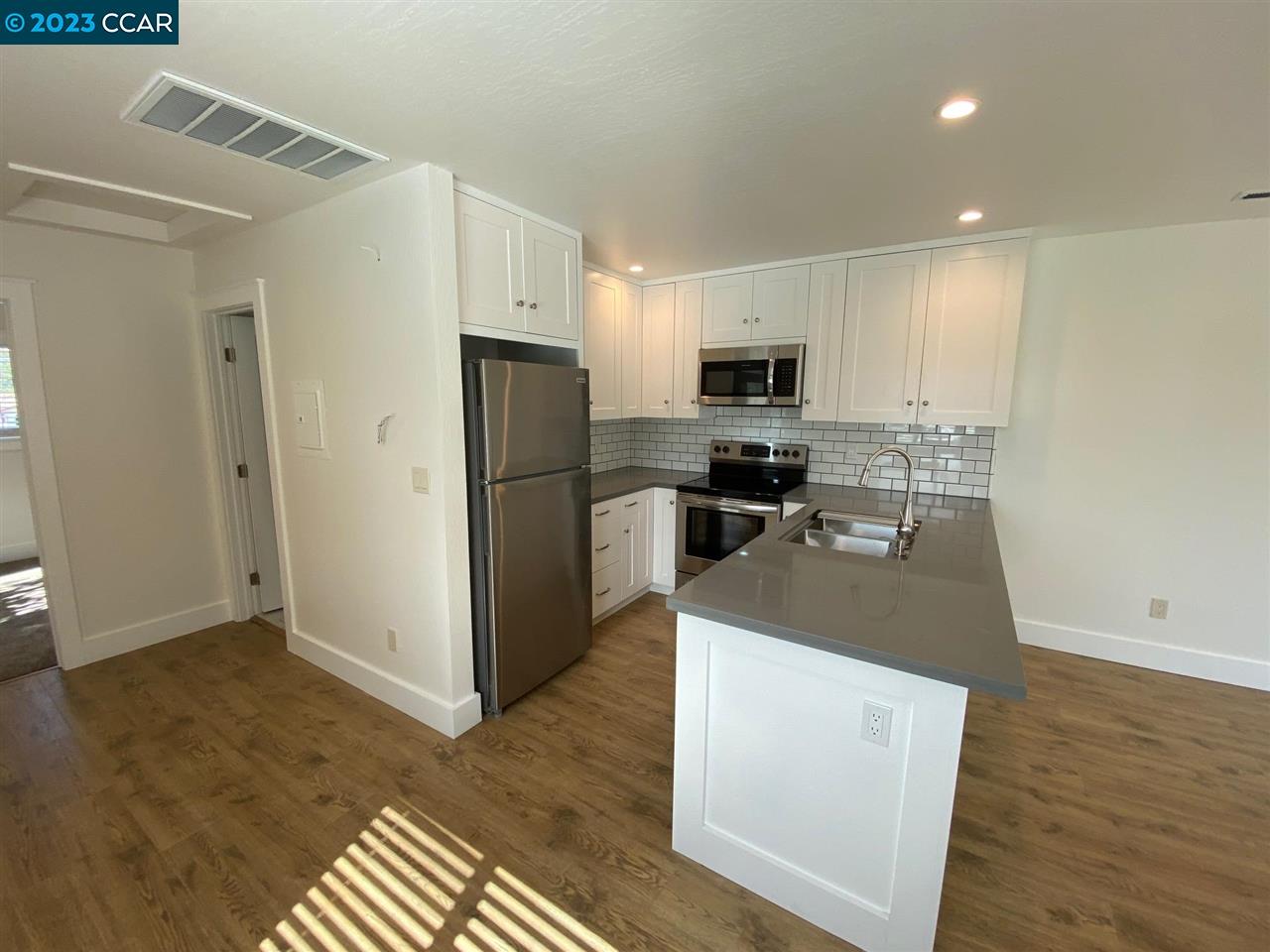 4882 San Pablo Dam Road, Unit B El Sobrante, CA 94803 - Photo 4 of 12 a kitchen with kitchen island white cabinets and stainless steel appliances