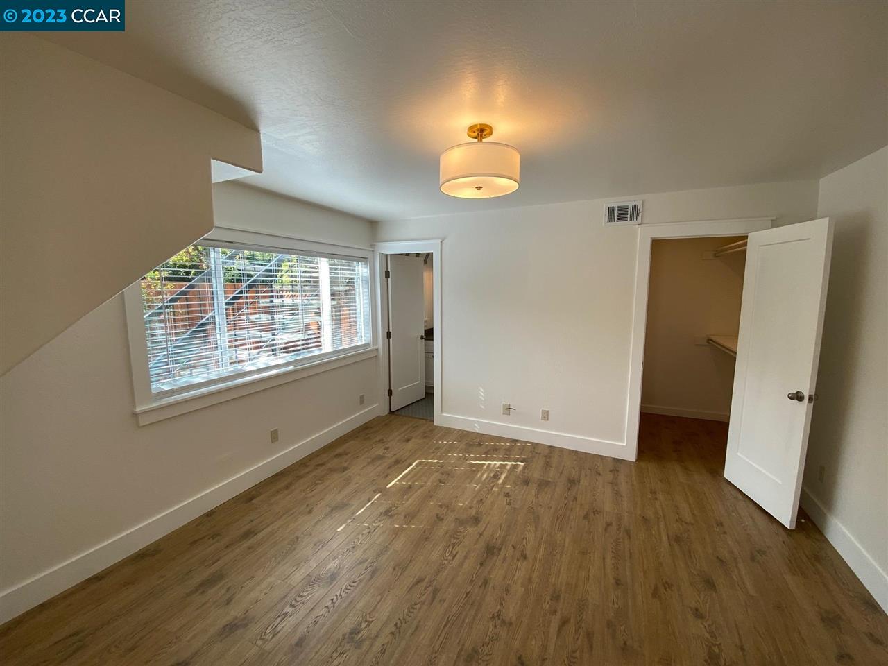 4882 San Pablo Dam Road, Unit B El Sobrante, CA 94803 - Photo 6 of 12 an empty room with wooden floor and windows