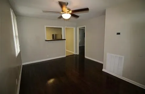 a view of an empty room with wooden floor