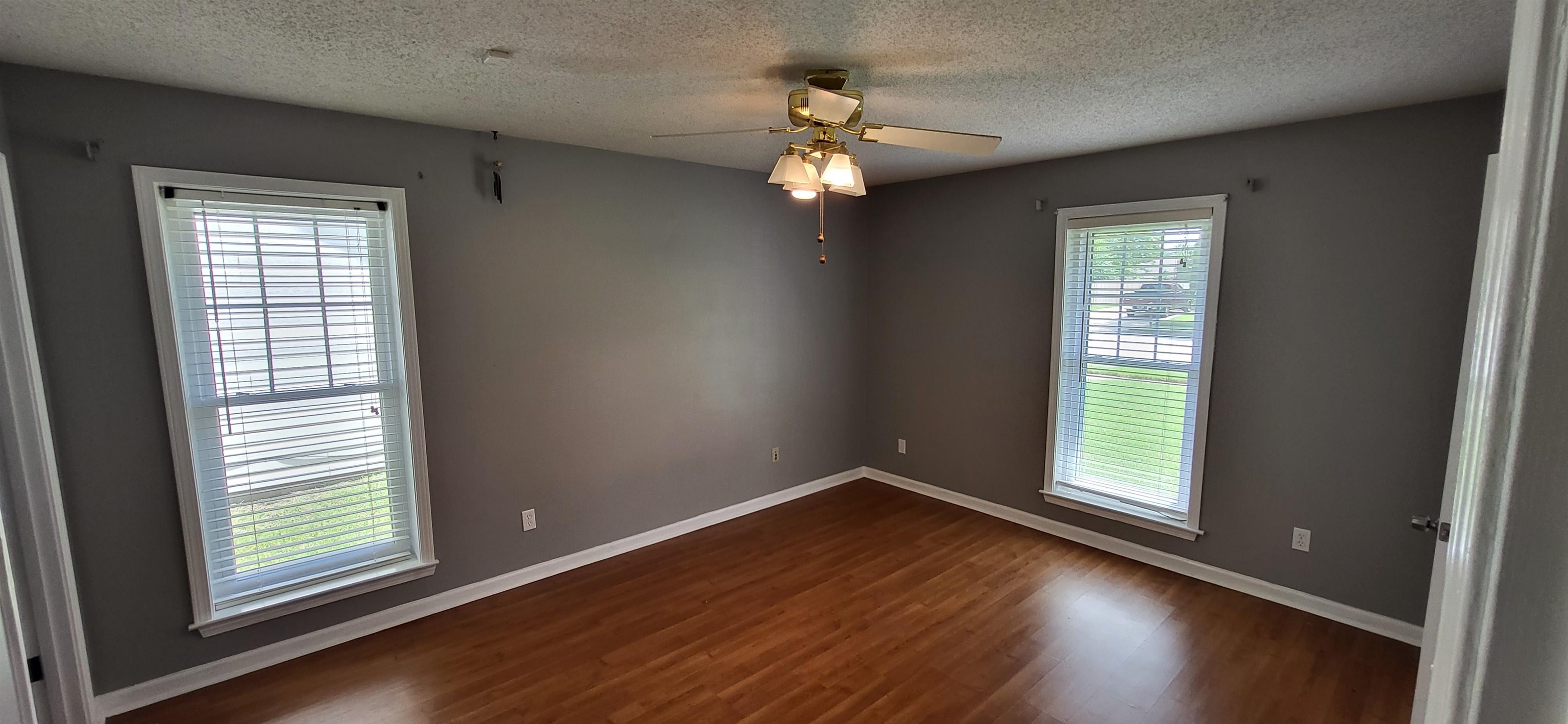 4567 Crump Road Memphis, TN 38141 - Photo 14 of 28 Empty room featuring healthy amount of natural light, dark wood-style floors, ceiling fan, and a textured ceiling
