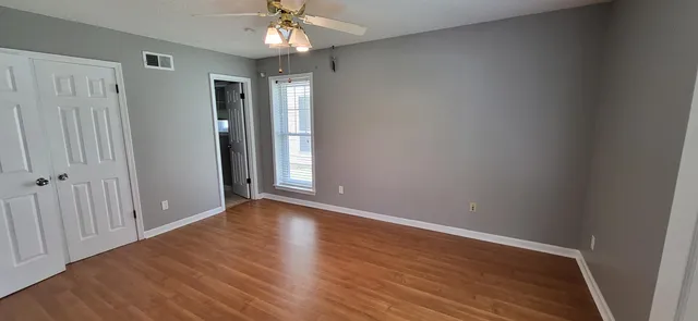 a view of an empty room with wooden floor